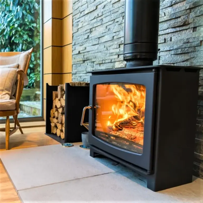Open fires vs wood burners UK: Traditional open fireplace with burning logs and higher emissions – Surrey & Sussex Stoves comparison