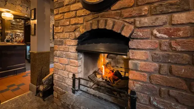 Wood burners vs open fires: Side-by-side comparison showing enclosed stove efficiency vs open fireplace waste – Surrey & Sussex Stoves